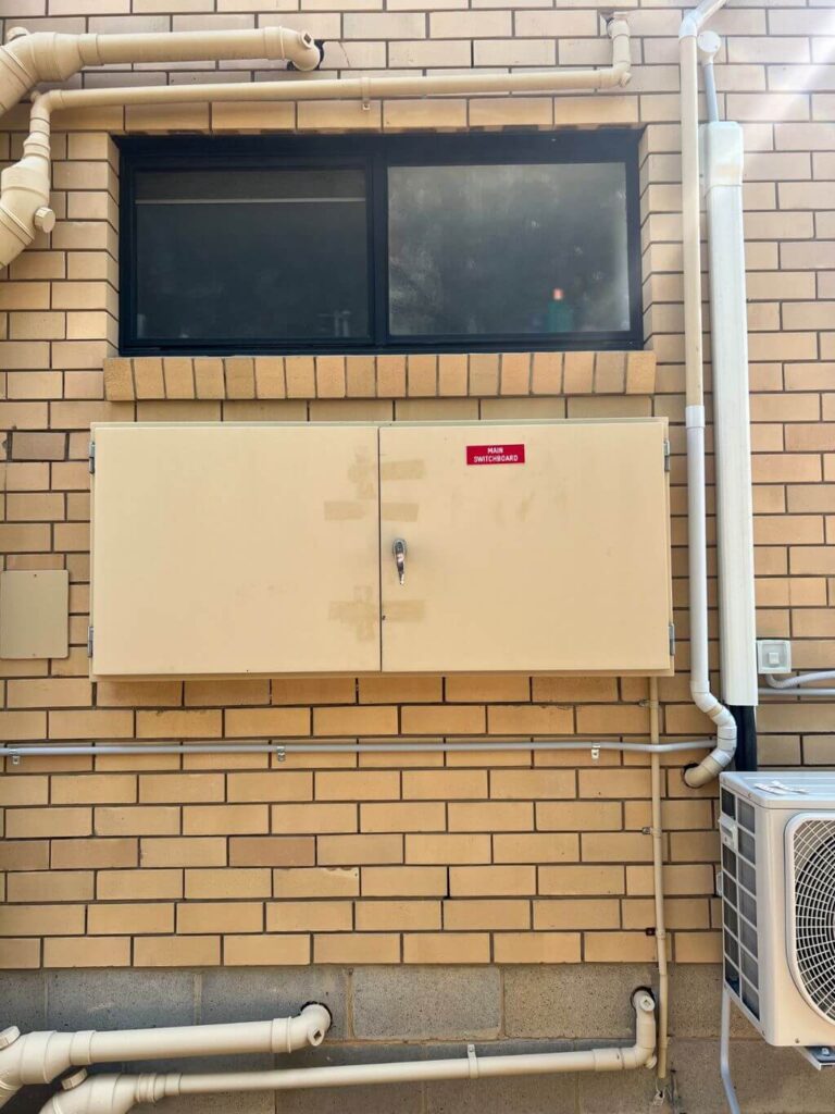 Common-area switchboard enclosure in a brick unit block