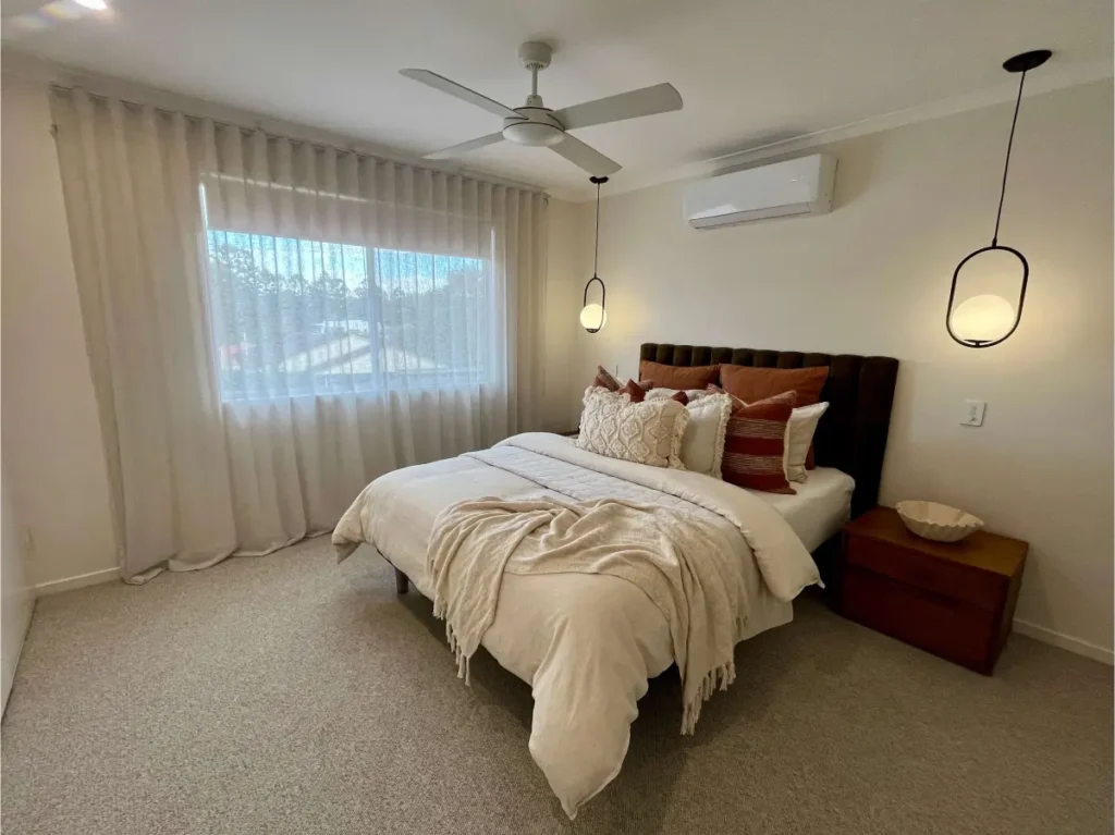 Bedroom with a wall-mounted split system air conditioner and ceiling fan