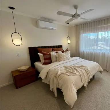 Bright bedroom with a quiet ceiling fan above the bed