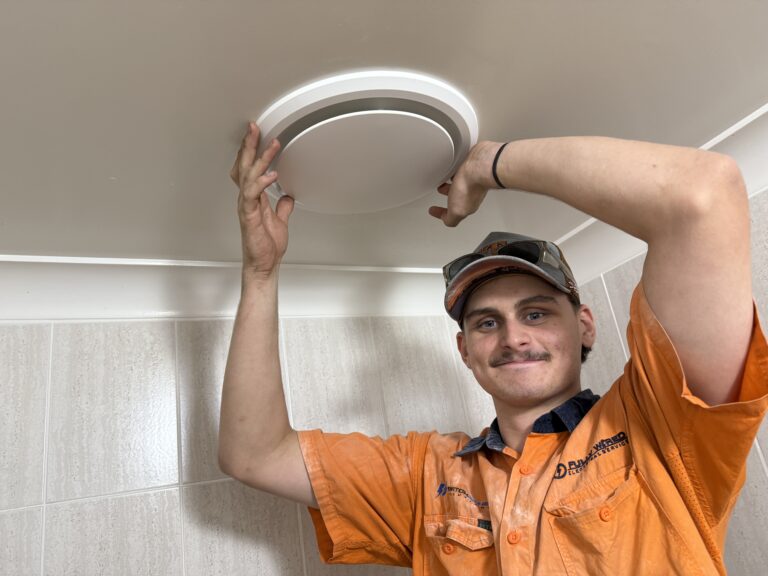 Fully Wired electrician installing a bathroom exhaust fan above a shower in Chapel Hill